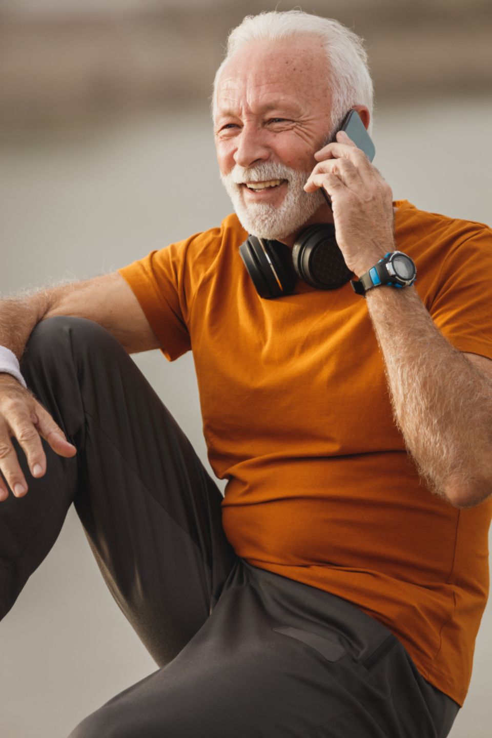 A cheerful older man talking on his phone